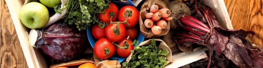 A freshly packed veg box with tomatoes, beetroot and herbs